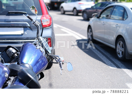 Blue motorcycle lying in front of car on road closeup Blue motorcycle lying in front of car on road closeup 78888221