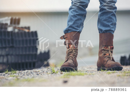 Men wear construction Boots safety footwear for worker at construction site. Engineer Wear Jeans Brown Boots Worker on Background of Refinery. Engineer safety industry fashion footwear walking outdoor 78889361