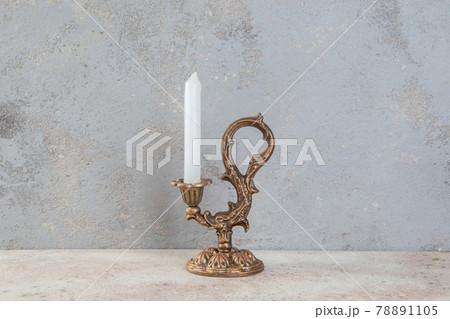 Antique candlestick on concrete background 78891105