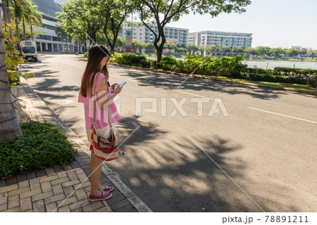 Young woman checking smart phone outdoors in sunny morning Young woman checking smart phone outdoors in sunny morning 78891211