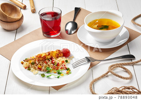 Kids set lunch of meat broth, rice with vegetables and chicken skewer, berry drink Kids set lunch of meat broth, rice with vegetables and chicken skewer, berry drink 78893048