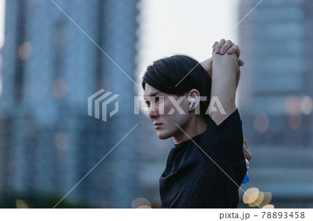 音楽を聞きながらジョギングの準備をする若い男性 音楽を聞きながらジョギングの準備をする若い男性 78893458