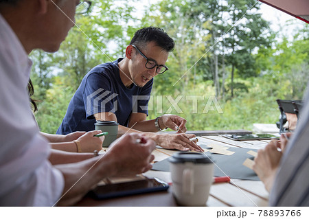 テラスで打ち合わせする男女 78893766