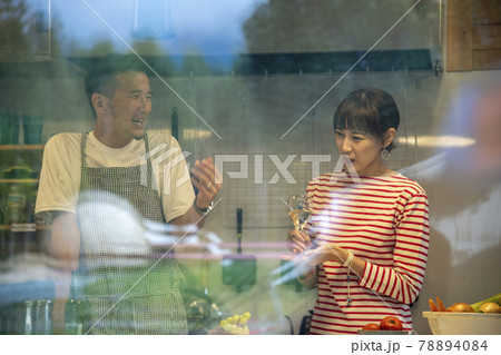 共同キッチンで談笑する男女 78894084