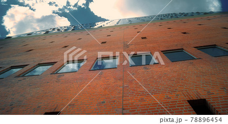 Abstract image of the brickwork of a large building, photographed from below with wide angle optics at an acute angle, architecture 78896454