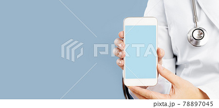 Doctor holding a mockup smartphone with an medical app Doctor holding a mockup smartphone with an medical app 78897045