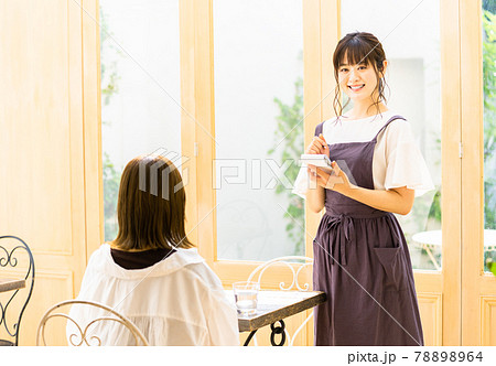 カフェで注文を聴く若い女性店員 カフェで注文を聴く若い女性店員 78898964