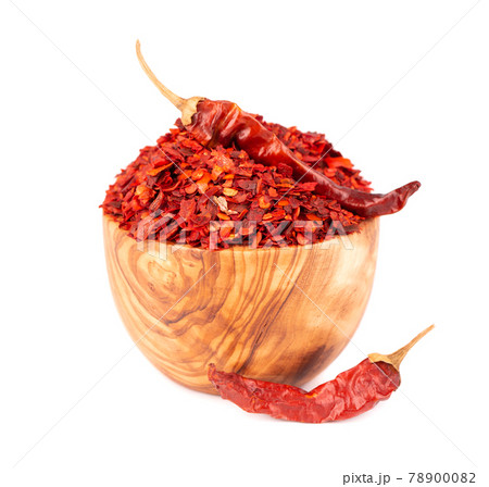 Dried red chili flakes in olive bowl, isolated on white background. Chopped chilli cayenne pepper. Spices and herbs. Dried red chili flakes in olive bowl, isolated on white background. Chopped chilli cayenne pepper. Spices and herbs. 78900082