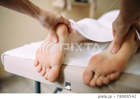 The masseur gives a massage to the female feet at the spa. The masseur gives a massage to the female feet at the spa. 78900542
