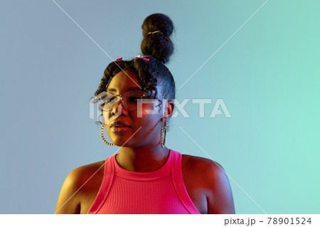Young beautiful happy African girl isolated on blue-green background in neon. 78901524