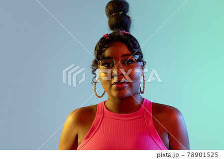 Young beautiful happy African girl isolated on blue-green background in neon. Young beautiful happy African girl isolated on blue-green background in neon. 78901525