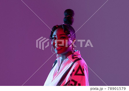 Young beautiful happy African girl isolated on purple background in neon. Young beautiful happy African girl isolated on purple background in neon. 78901579