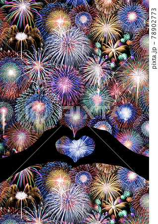 幸せを呼ぶ写真 夜空一面の花火とハート型の手のシルエット の写真素材