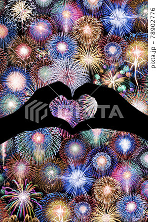 幸せを呼ぶ写真 夜空一面の花火とハート型の手のシルエット の写真素材