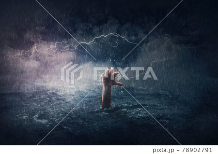 Arm drowning in the sea. Surreal and dramatic scene of person hand sinking in the ocean under a hurricane stormy weather. People need help in risk situations. Despair, depression and failure metaphor 78902791