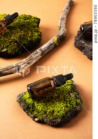 Bottles of cosmetic product on concrete stone with moss and wooden branch on beige background Bottles of cosmetic product on concrete stone with moss and wooden branch on beige background 78903560
