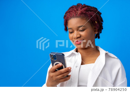 African american woman using smartphone against blue background 78904250