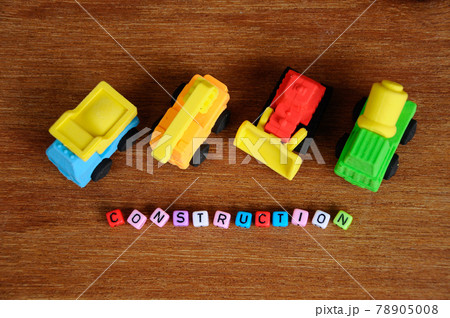 Miniature model of construction heavy machine made from synthetic rubber on wood texture background. Miniature model of construction heavy machine made from synthetic rubber on wood texture background. 78905008