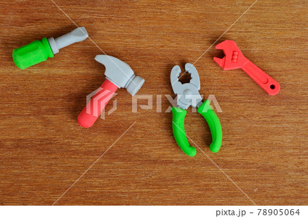 Miniature model of construction heavy machine and construction tools, both made from synthetic rubber on wood texture background. Construction text printed on small plastic block in the middle. Miniature model of construction heavy machine and construction tools, both made from synthetic rubber on wood texture background. Construction text printed on small plastic block in the middle. 78905064
