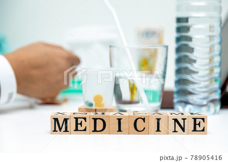 Close up medicine wooden block word on table with tablet and drinking water Close up medicine wooden block word on table with tablet and drinking water 78905416