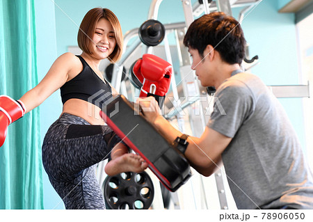 ミットにキックを打つ女性と男性トレーナー ミットにキックを打つ女性と男性トレーナー 78906050