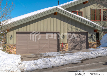 Facade of an attached garage with gray doors and gable roof in Park City Utah 78906795