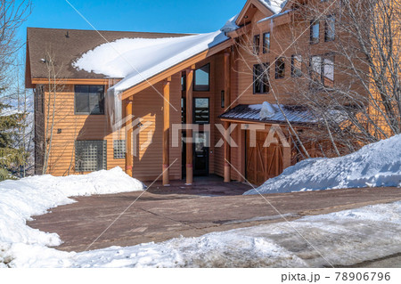 Facade of Park City Utah mountain home with brown exterior wall and snowy roof 78906796