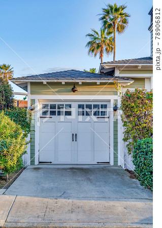 Hinged wooden garage door with glass panes and hip roof in San Diego California 78906812