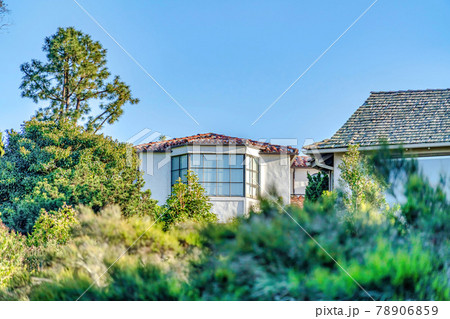 Home exterior with bay window against blue sky and green foliage on a sunny day Home exterior with bay window against blue sky and green foliage on a sunny day 78906859