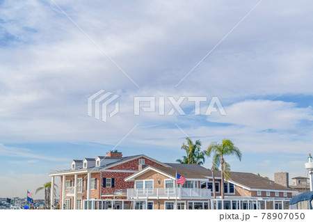 Blue sky and gray clouds over lovely houses in Huntington Beach California Blue sky and gray clouds over lovely houses in Huntington Beach California 78907050