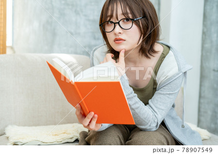 部屋で本を読んで過ごすメガネを掛けた女性 部屋で本を読んで過ごすメガネを掛けた女性 78907549