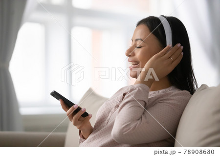 Excited African American music fan wearing headphones Excited African American music fan wearing headphones 78908680