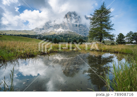 Woman hiking in Val Gardena. Pond and reflection of Sassolungo Langkofel mountain. Dolomites, Italy 78908716