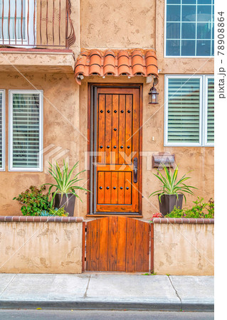 Facade of charming houses in Long Beach with an overhang above the front door 78908864