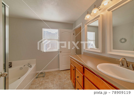Interior of residential bathroom with vanity built in bathtub and tiles on floor Interior of residential bathroom with vanity built in bathtub and tiles on floor 78909119