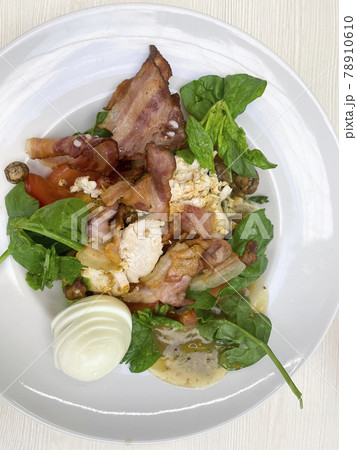 Fresh summer salad with bacon on white plate 78910610