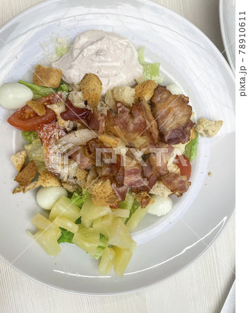 Fresh summer salad with bacon on white plate 78910611