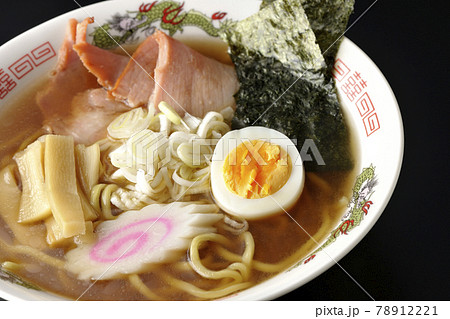 チャーシューなど色々な具材が乗っている屋台で食べるような昔ながらの醤油ラーメンを黒背景で撮影 78912221