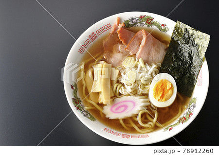 チャーシューなど色々な具材が乗っている屋台で食べるような昔ながらの醤油ラーメンを黒背景で俯瞰撮影 78912260