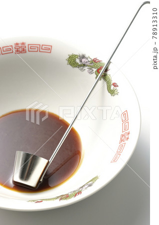 ラーメンどんぶりに醤油ラーメンの元とレードルが入ってる様子を白背景で撮影 78913310