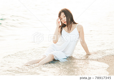 海辺に座るワンピースの女性 海辺に座るワンピースの女性 78917345