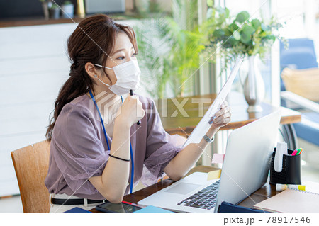 カフェ風オフィスでマスクをして仕事をする女性 78917546