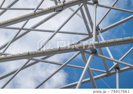 Abstract image of white steel struts and supports in front of a white-blue sky 78917661