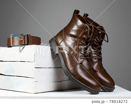 Male boots and belt on white wooden box Male boots and belt on white wooden box 78918272