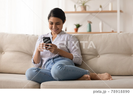 Smiling Indian woman use cellphone browsing internet Smiling Indian woman use cellphone browsing internet 78918890