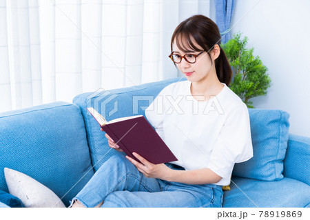 ソファで読書をする眼鏡の女性 78919869