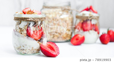 Healthy breakfast. Oatmeal Granola with greek yogurt and nuts strawberry muesli in jars on light background. Vegan, vegetarian and weight loss diet concept. Detox menu. Healthy breakfast. Oatmeal Granola with greek yogurt and nuts strawberry muesli in jars on light background. Vegan, vegetarian and weight loss diet concept. Detox menu. 78919903