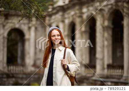 Happy caucasian female Traveler with backpack walking in historical site 78920121