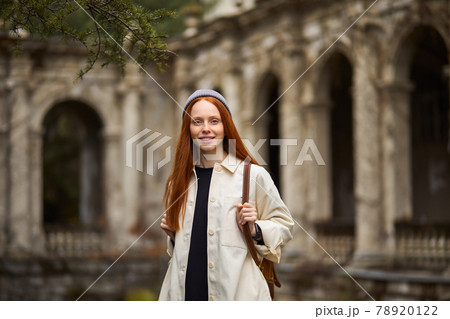 Pretty redhead woman in coat in search of beautiful historical place 78920122