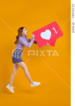 female chasing likes, jumping woman keeping heart social media icon looking copyspace 78920235